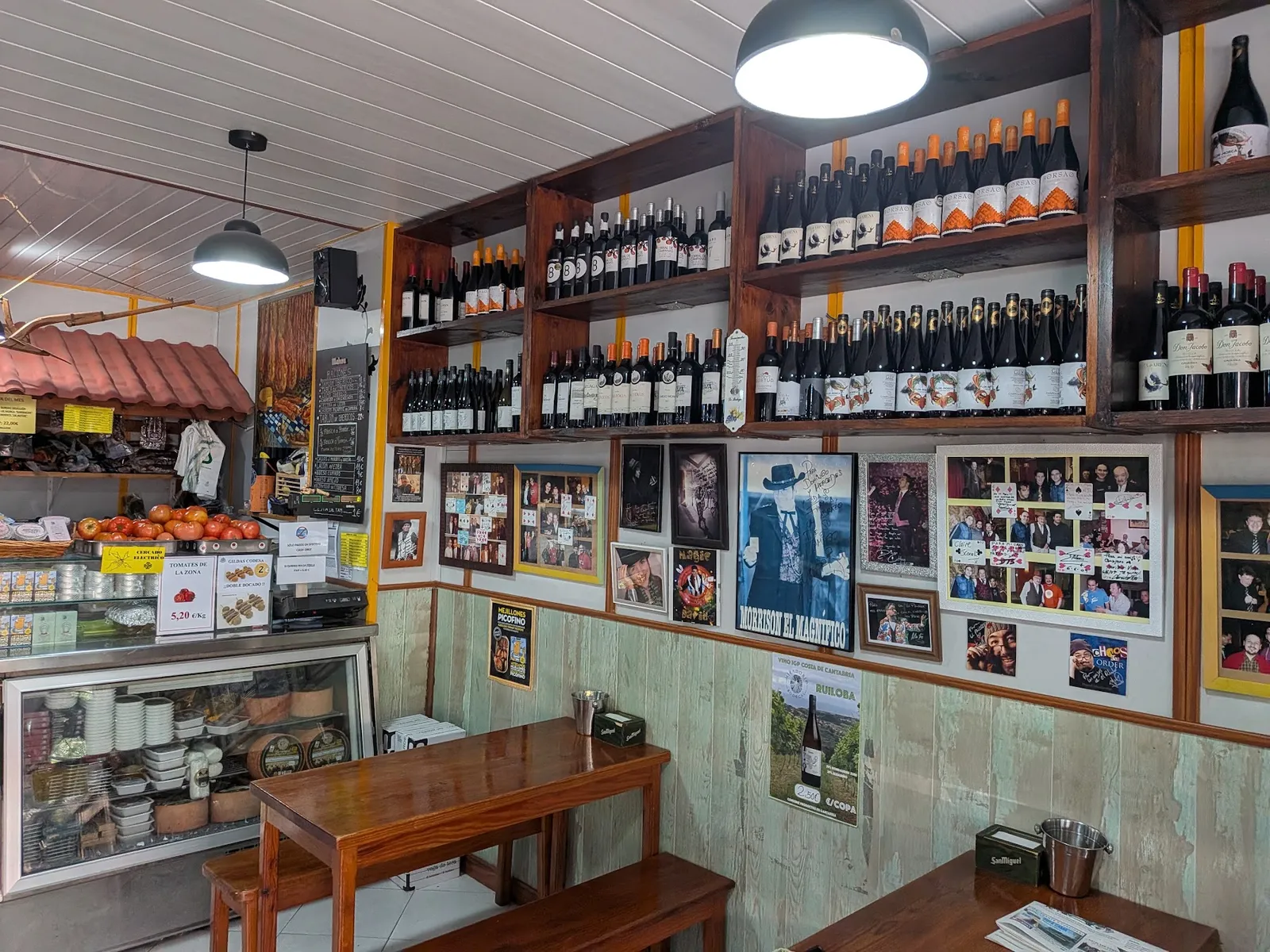 La barra de El Paladar, con la pared de vinos y las fotos de los clientes